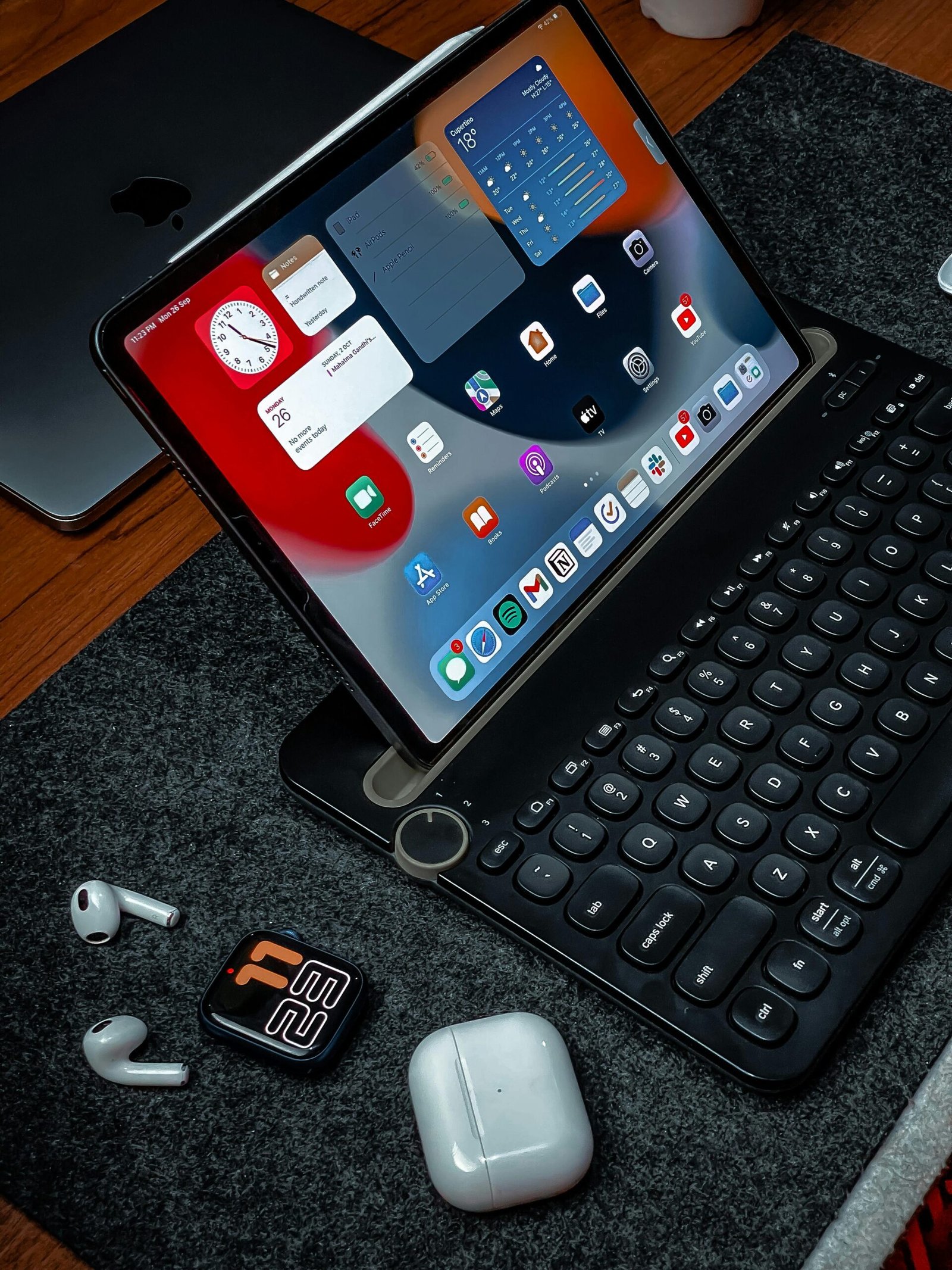 A sleek home office setup featuring a tablet with keyboard and wireless earbuds, perfect for work or study.